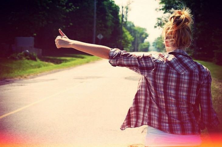 Moça pedindo carona em foto cheia de efeitos.
