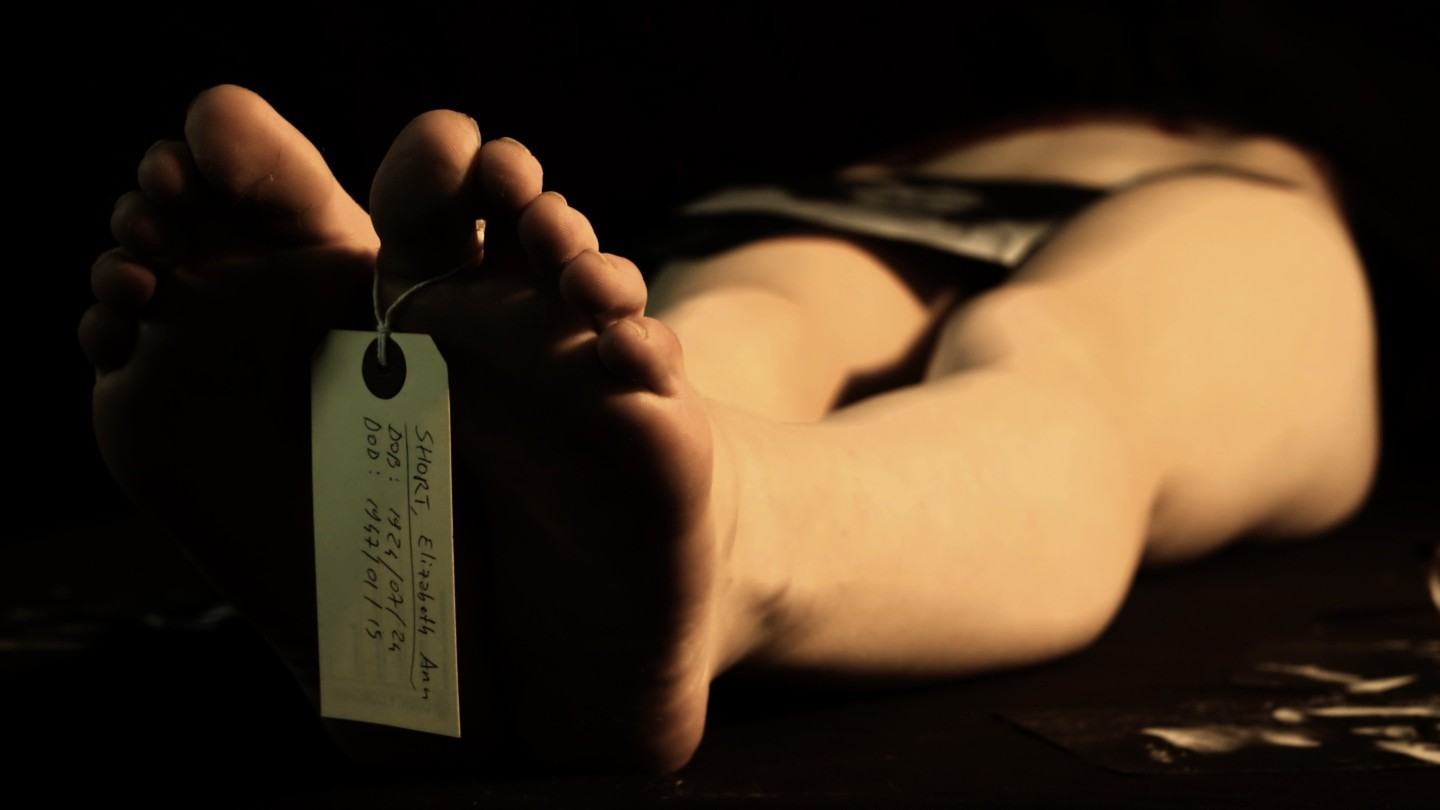 Foto fictícia de um cadáver com etiqueta de identificação no dedão.