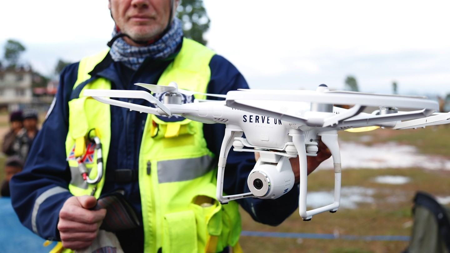 Homem segura um drone que ajudará no pós-terremoto, no Nepal.