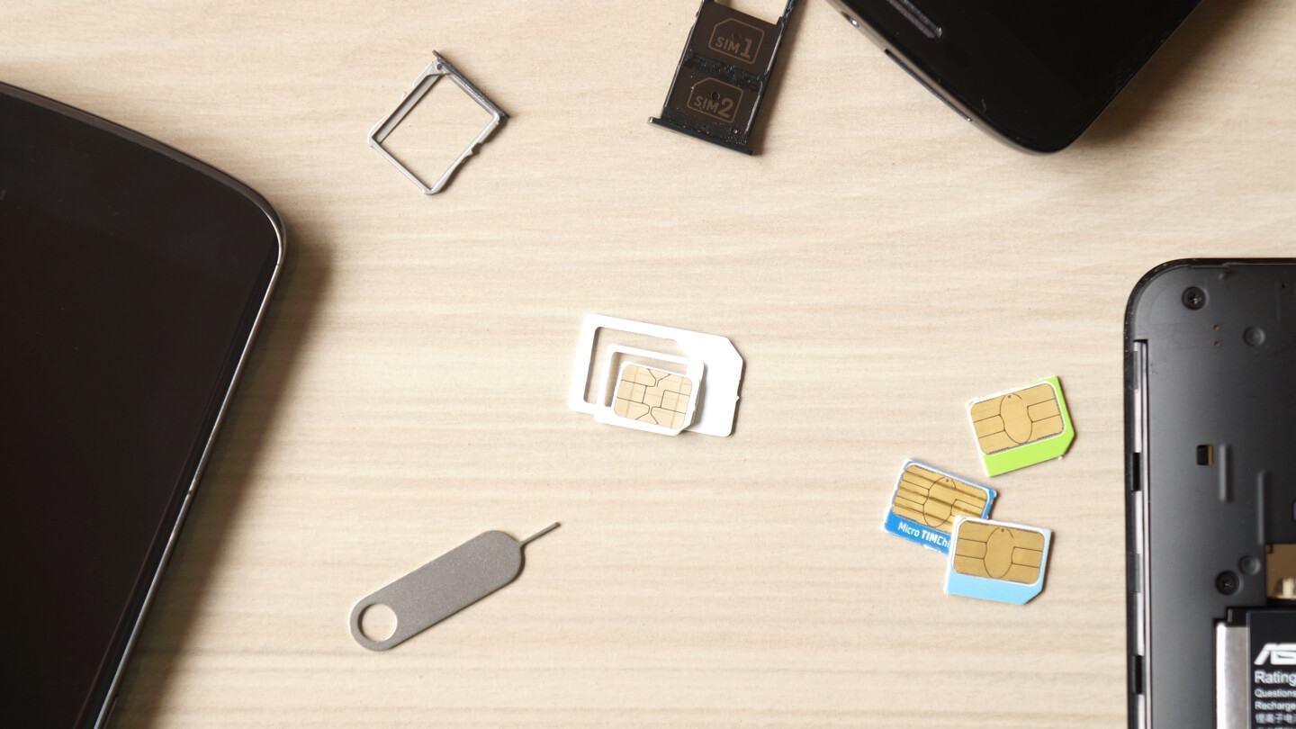 Chip SIM card triplo corte ladeado por celulares, ferramentas e outros chips.