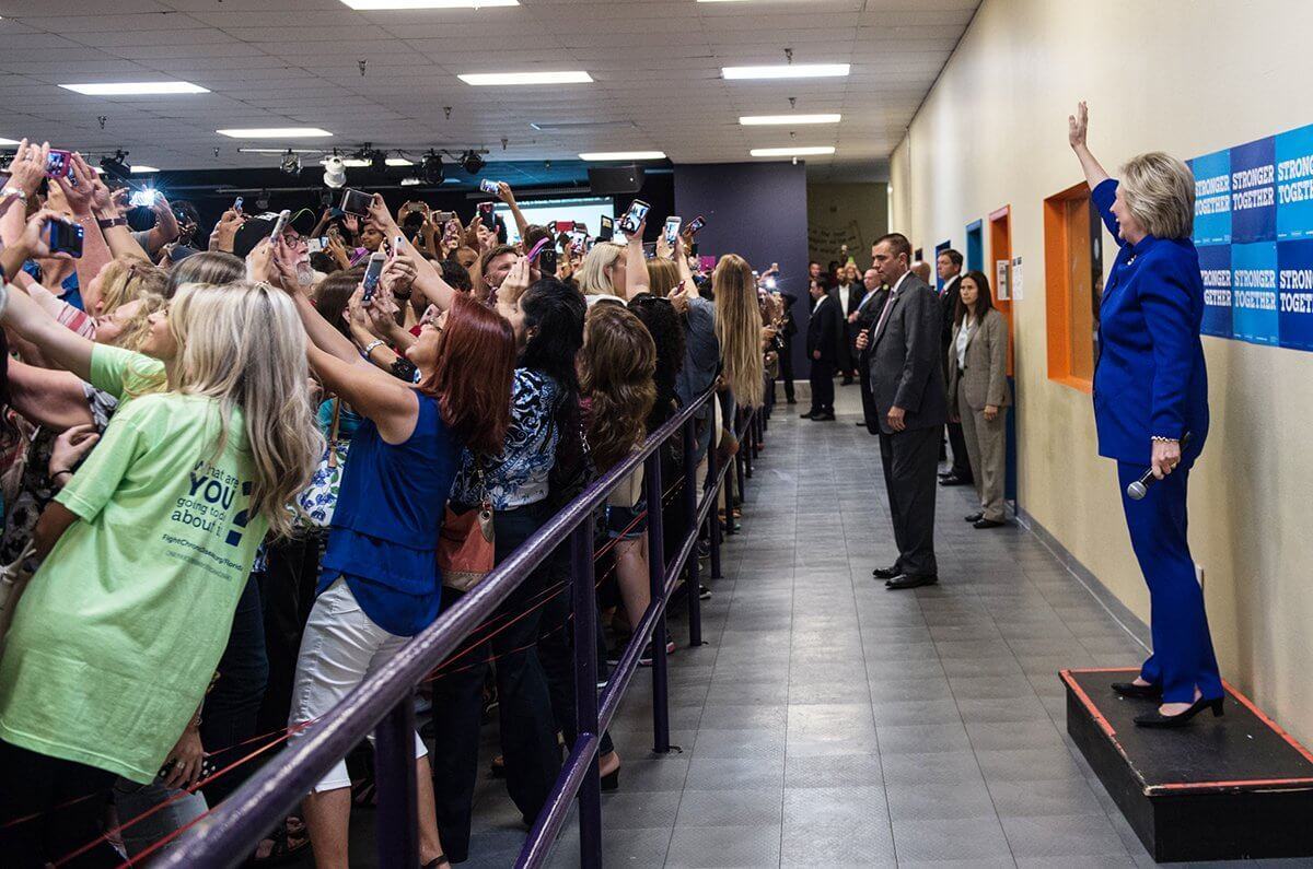 Eleitores tiram selfies à distância com a candidata Hillary Clinton.