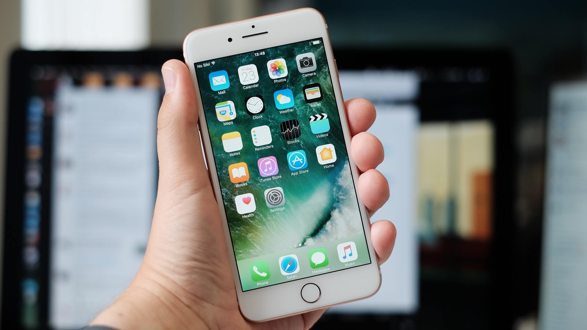 Mão segurando um iPhone 7 Plus na cor ouro rosa.