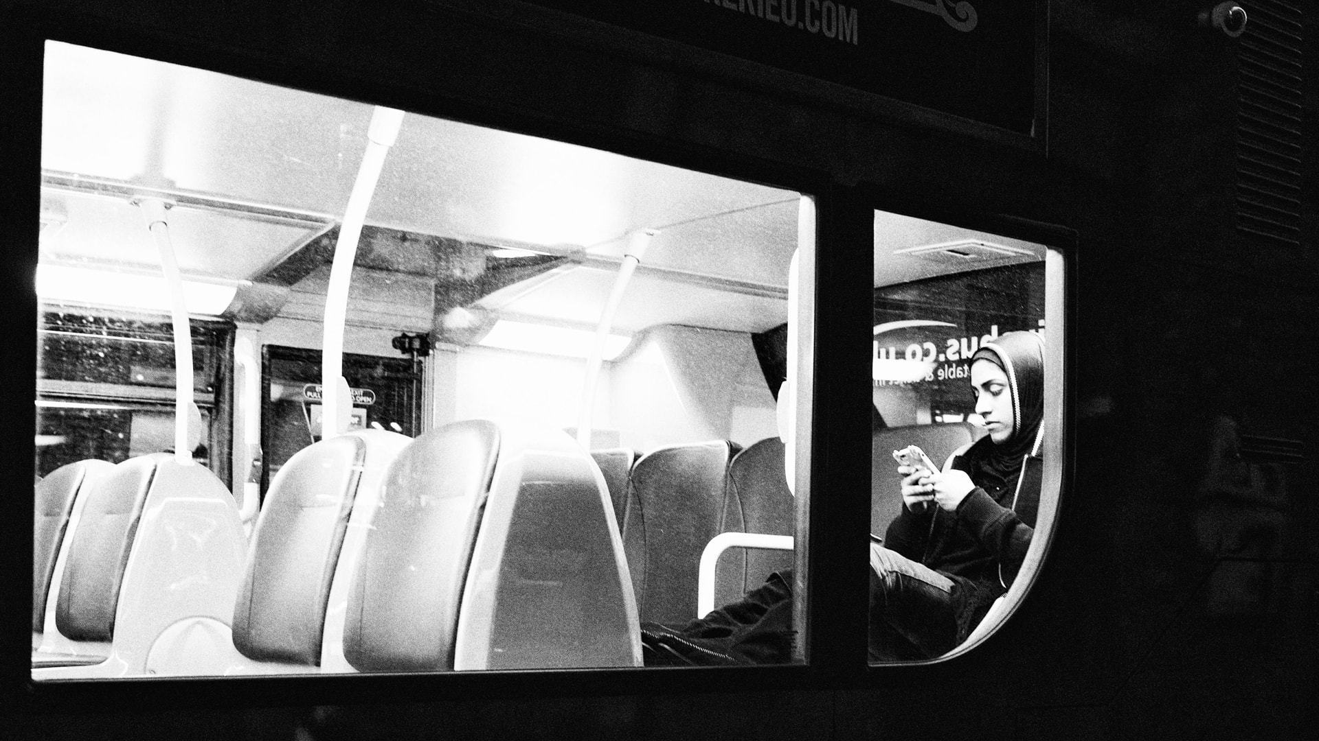 Mulher usando smartphone no ônibus.
