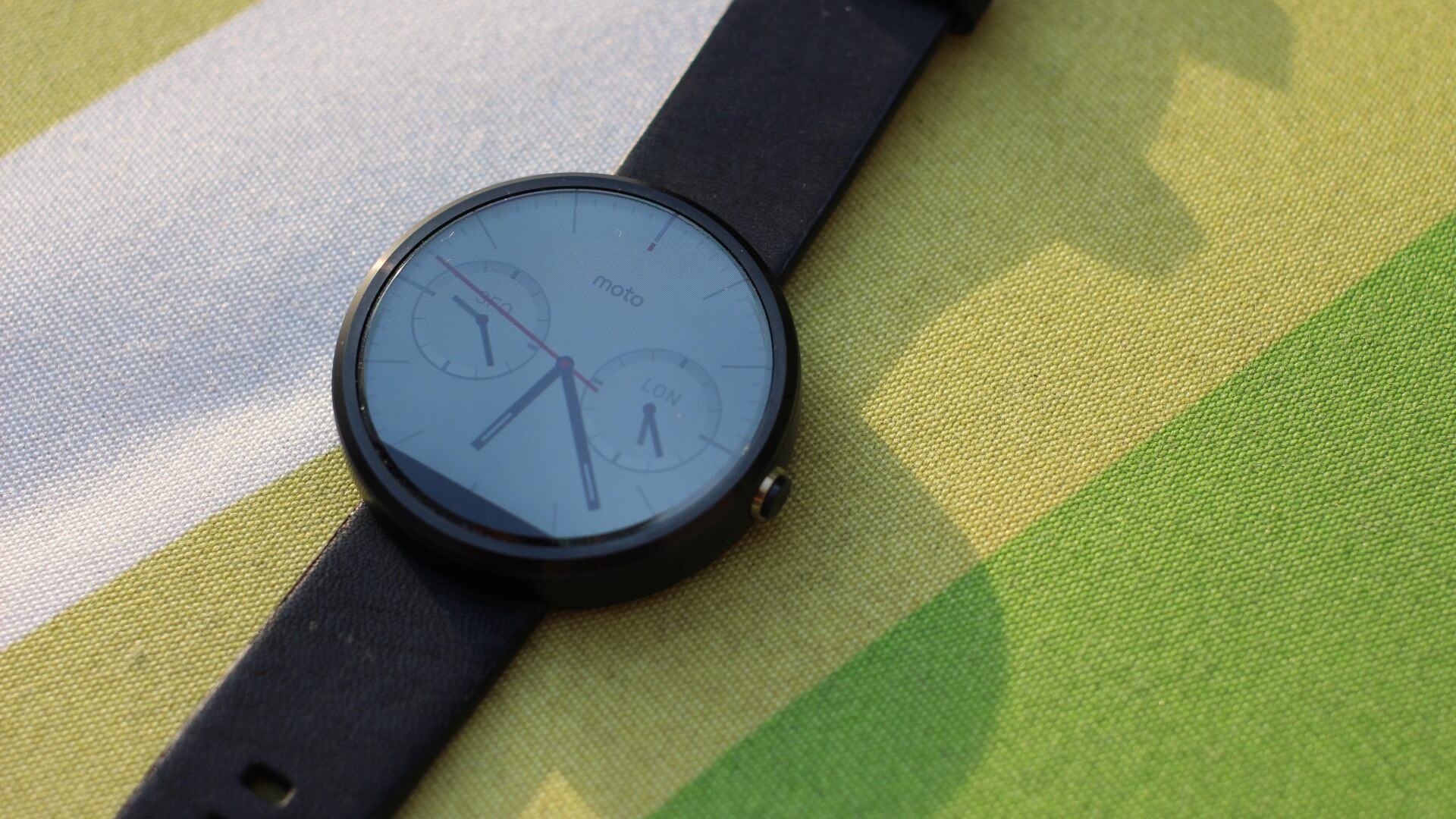 Moto 360 sobre uma colcha verde.