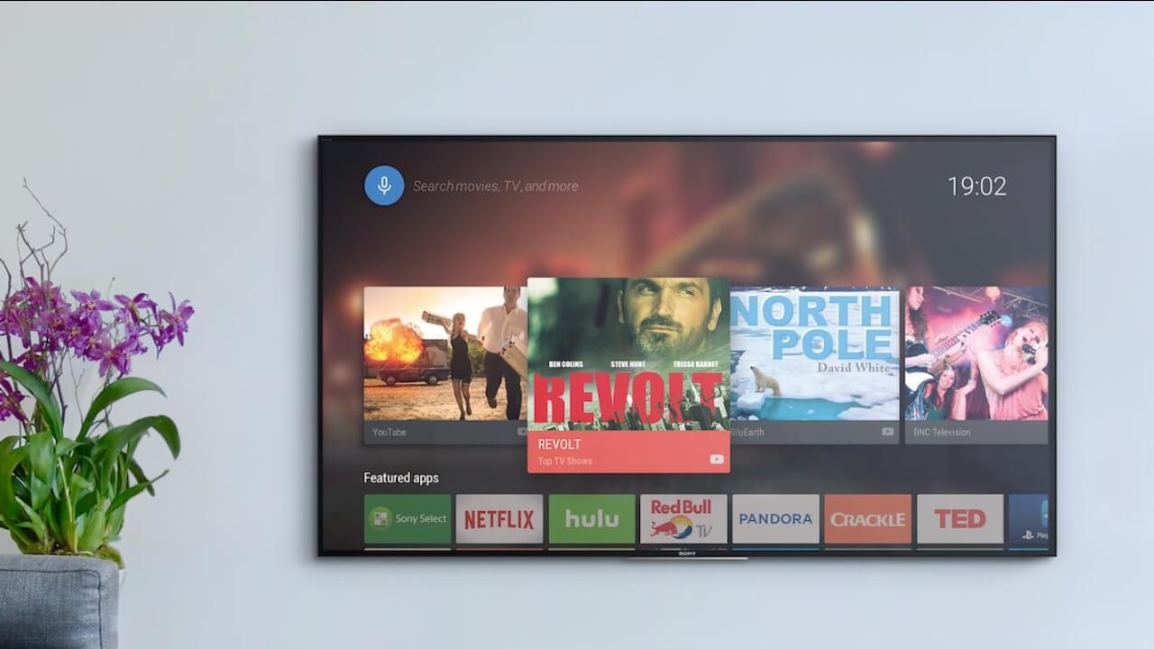 Smart TV com Android TV pendurada na parede.