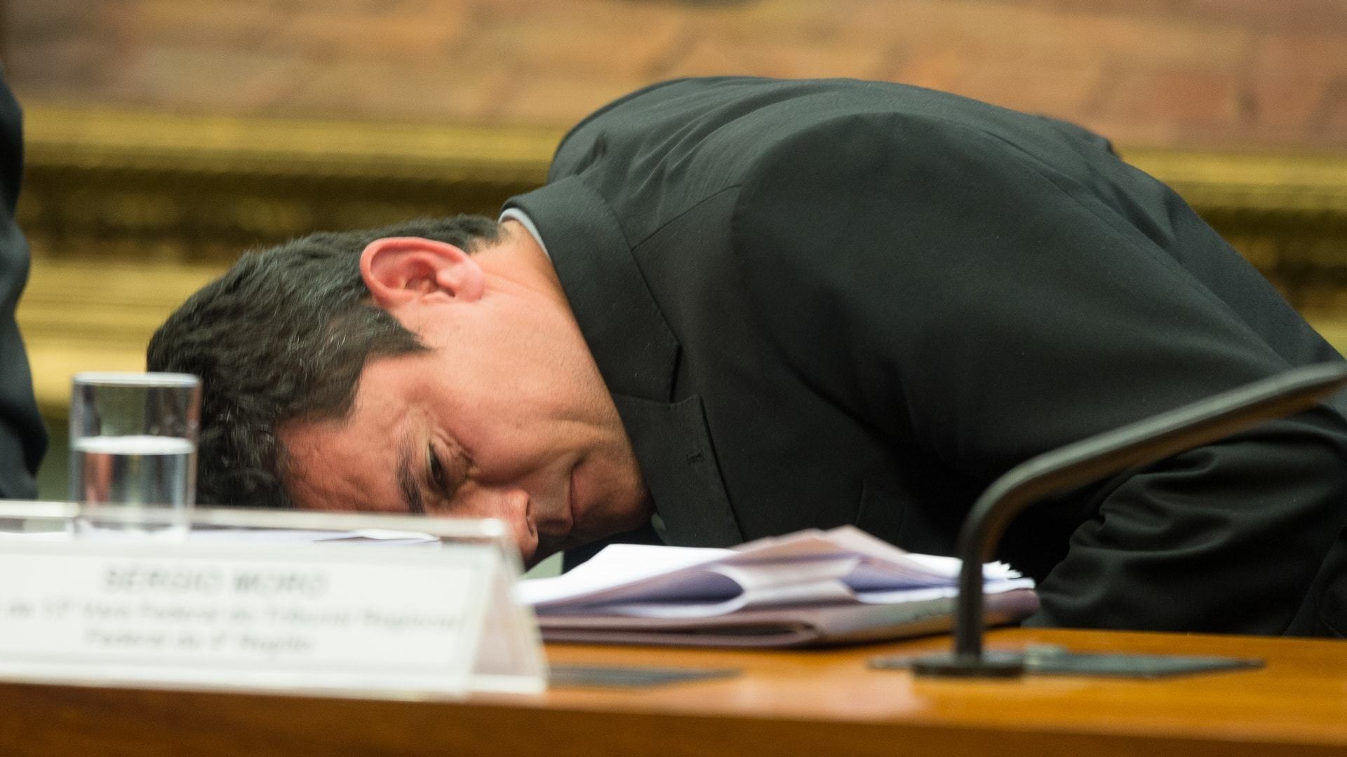 Sergio Moro deitado sobre uma mesa.