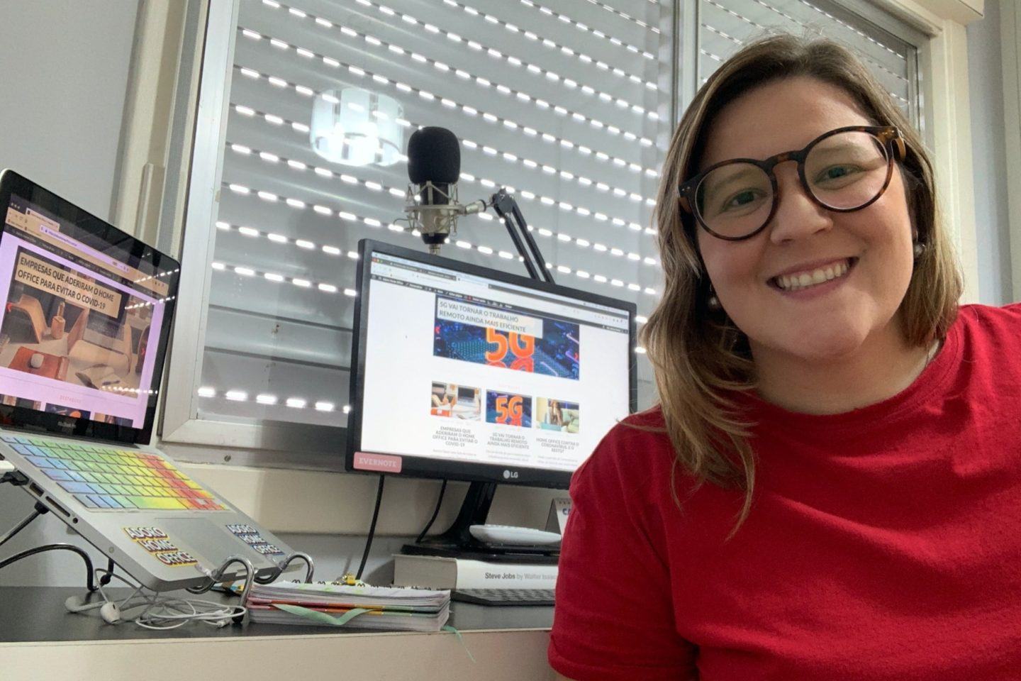 Marcia Breda em frente à sua mesa de trabalho de home office.