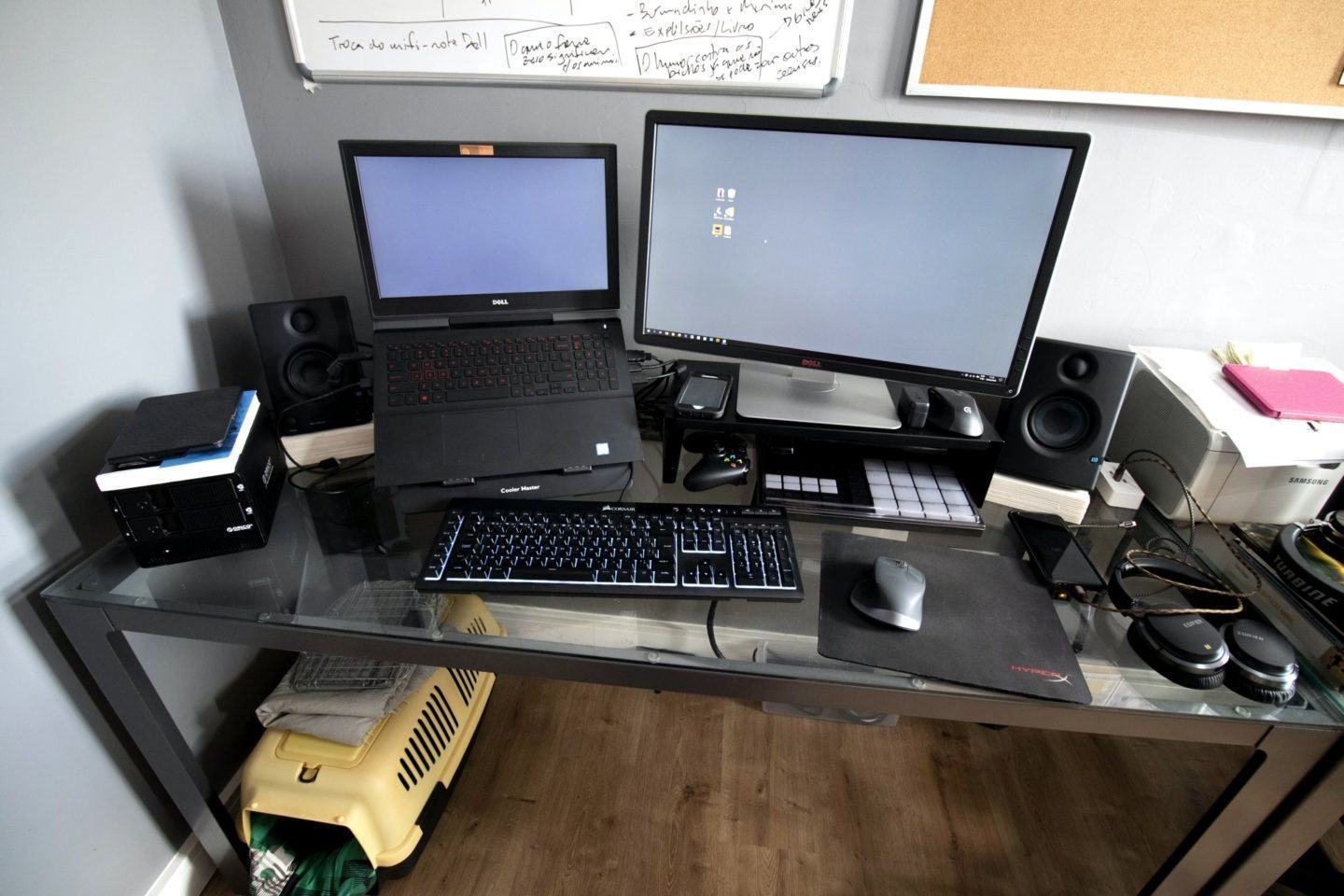 Mesa de trabalho em escritório doméstico do Fabio Montarroios, com notebook, tela, celulares e acessórios em cima.