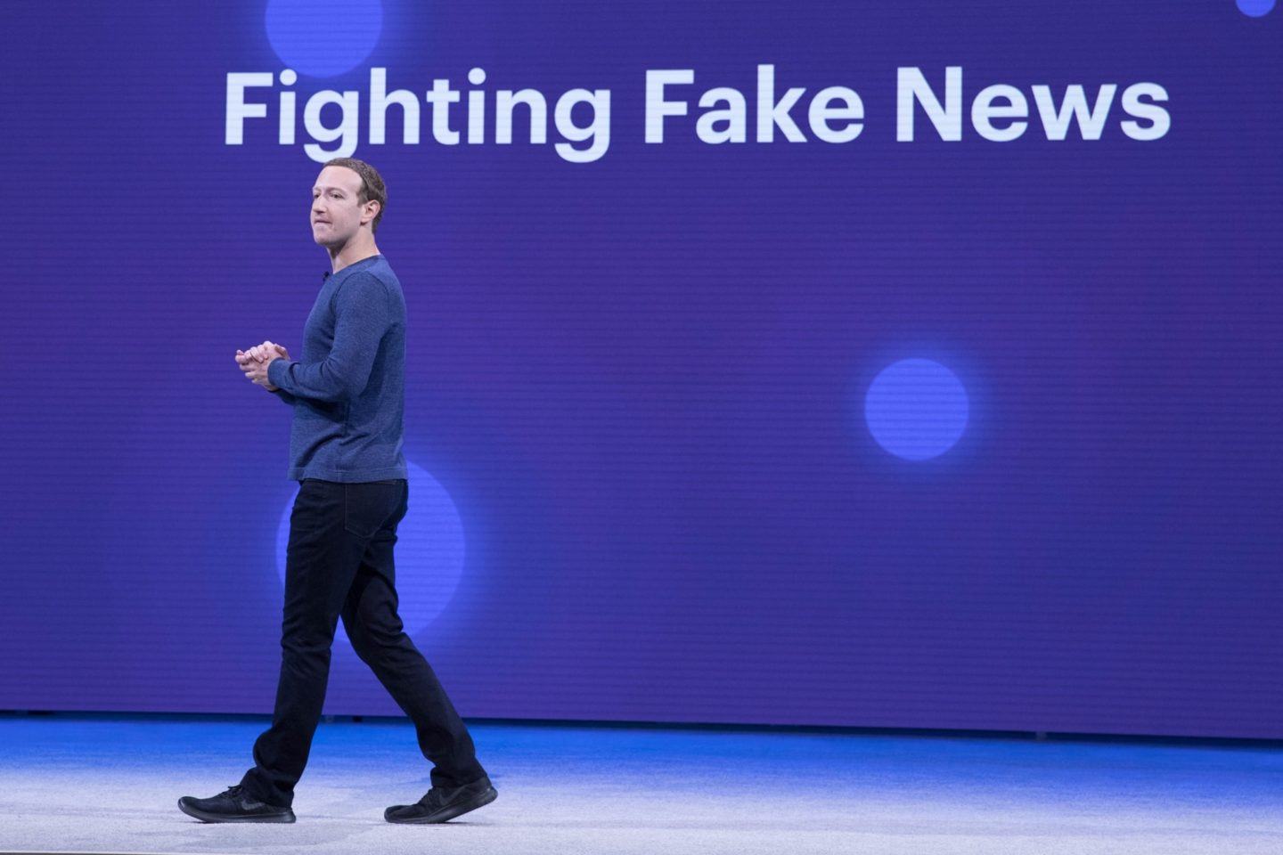 Zuckerberg no palco; ao fundo, letreiro diz "Combatendo notícias falsas".