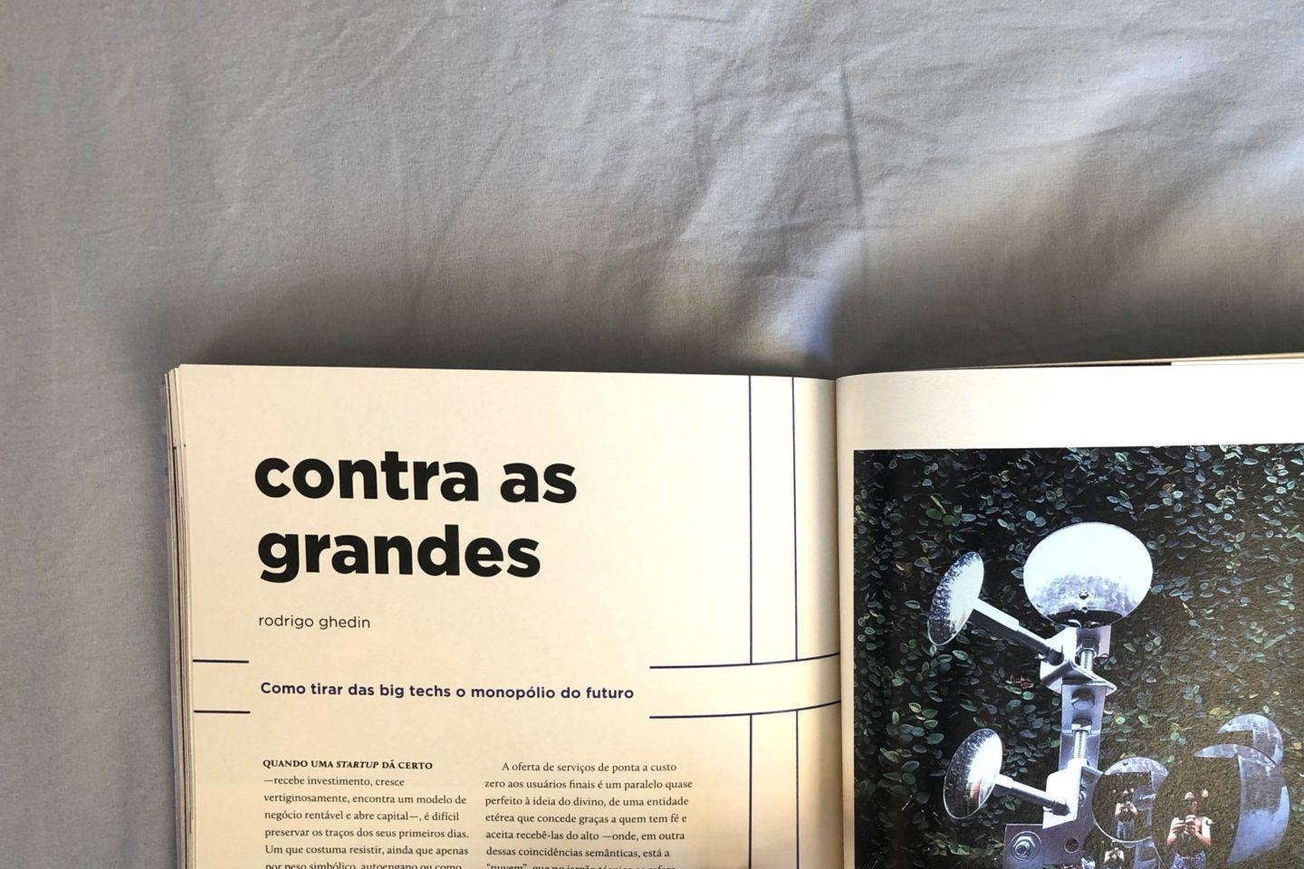 Edição impressa da revista Zero, aberta na matéria Contra as grandes, contra um fundo em tecido azul.
