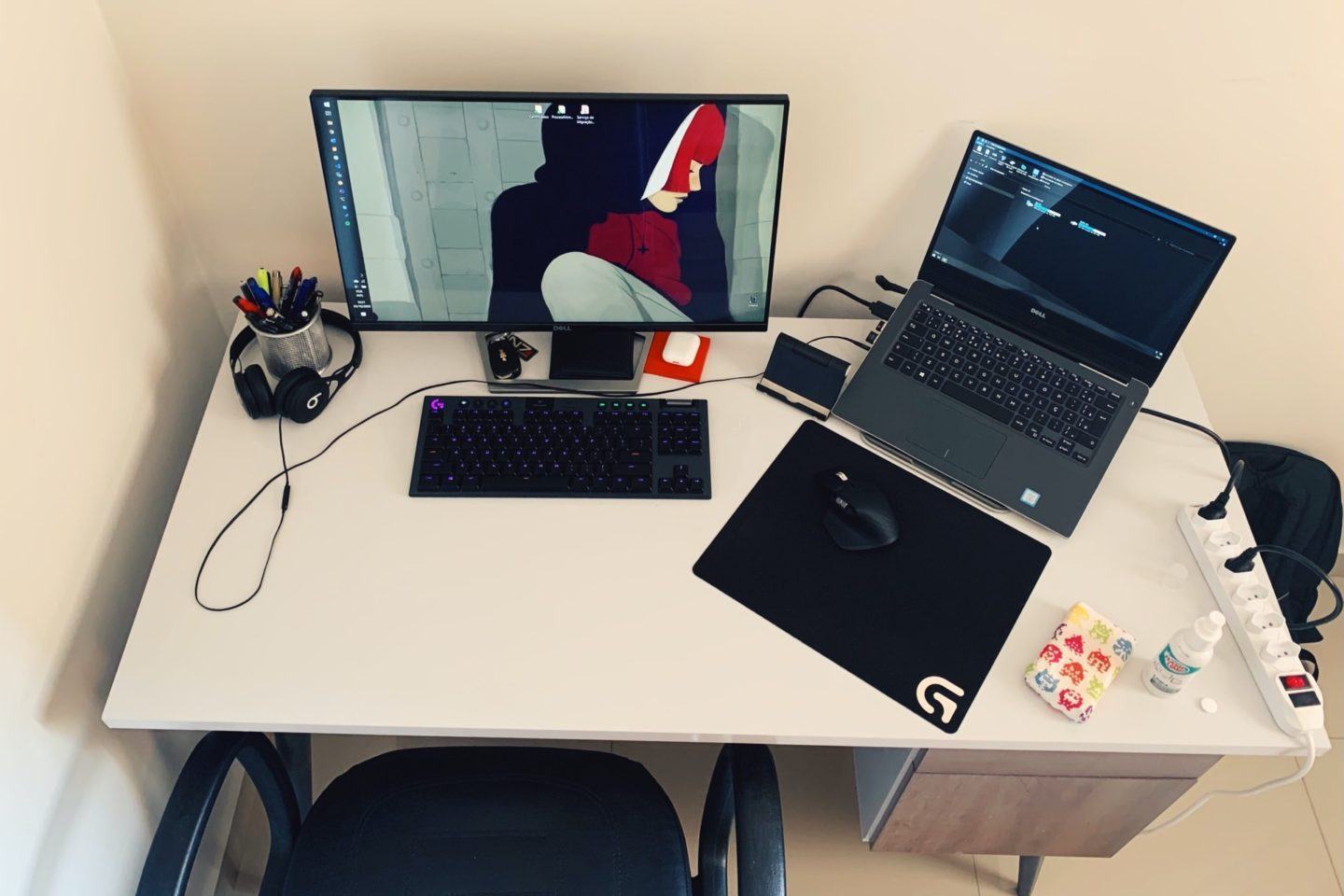 Visão de cima da mesa do Ulisses Campos, com notebook, monitor e acessórios (mouse, teclado etc.).