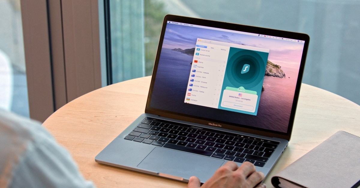 Notebook em uma mesa com o aplicativo do Surfshark aberto na tela.