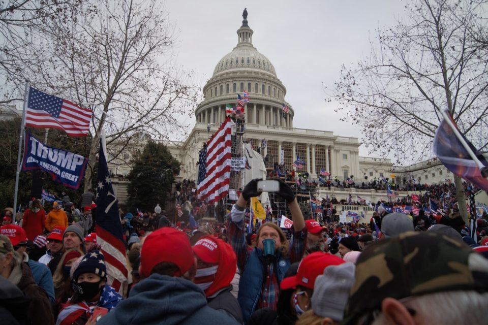 Manifestantes fiéis a Donald Trump cercam o Capitólio, ao fundo na imagem, no dia 6 de janeiro de 2021.