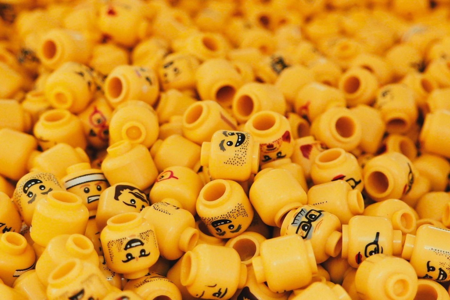 Incontáveis cabeças amarelas de Lego amontoadas.