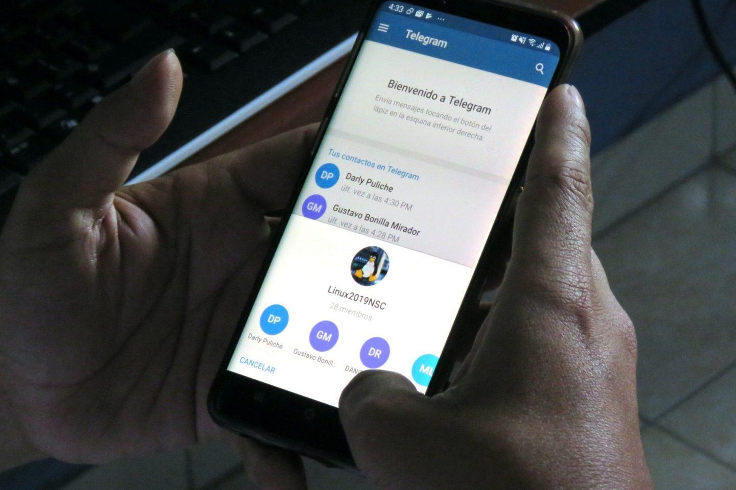 Mãos seguram um celular com um canal do Telegram aberto.