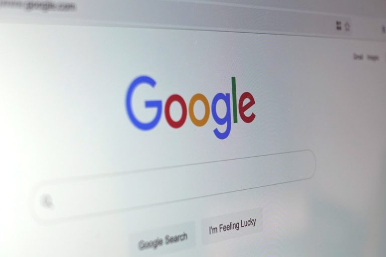 Foto de lado da página inicial do Google, em close, com o logo colorido do Google, o campo de pesquisa e dois botões embaixo.