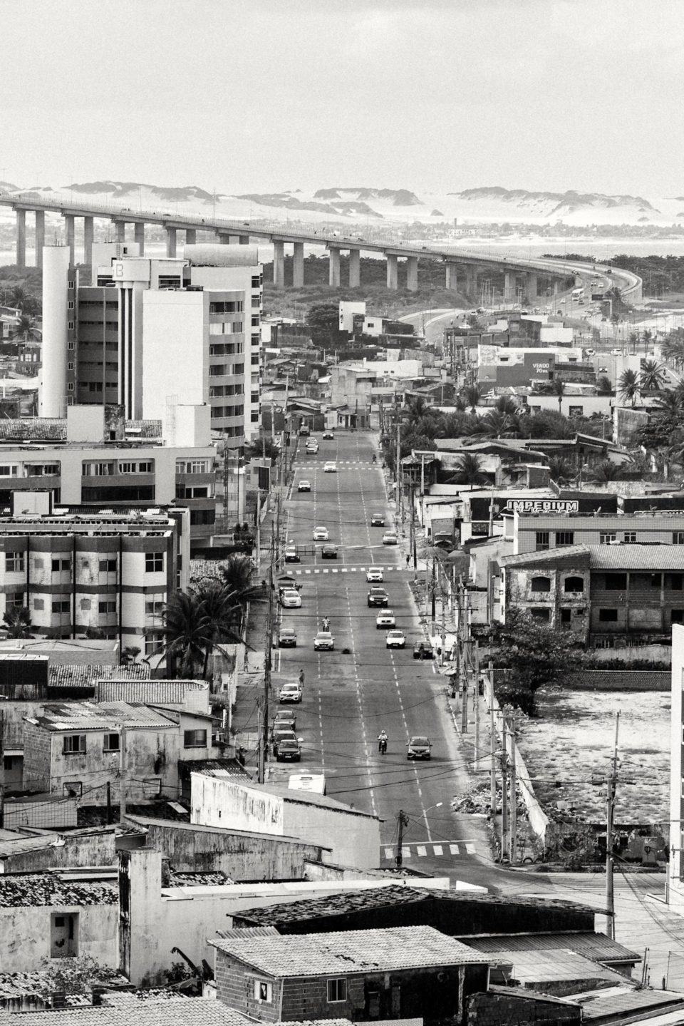 Foto em preto e branco de Natal (RN). Vista para avenida 25 de dezembro na Praia do Meio com a ponte Newton Navarro ao fundo.