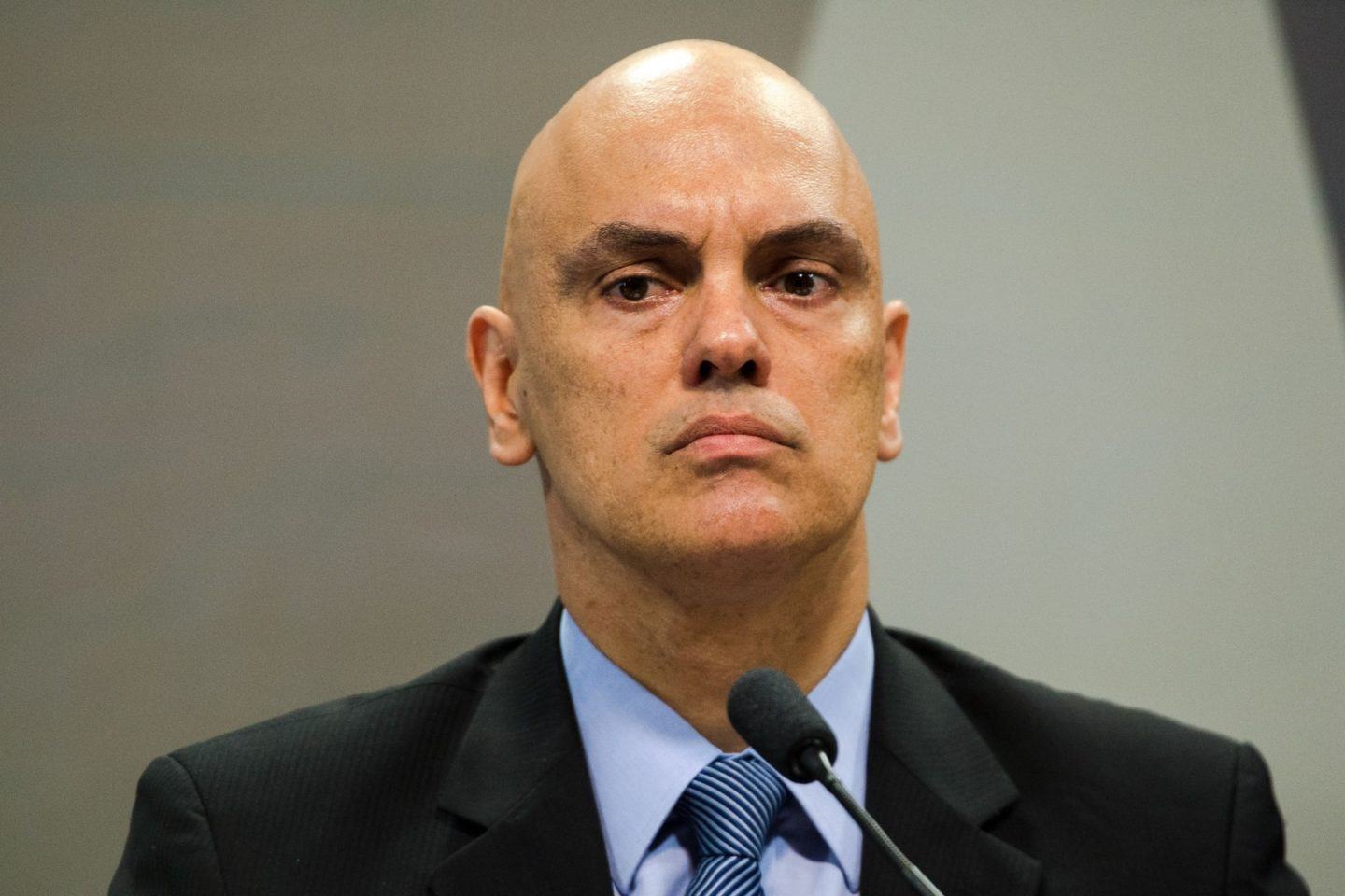 Alexandre de Moraes, homem branco, careca, de terno, com expressão fechada.