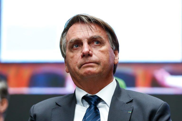 Homem branco, de cabelo curto, vestindo terno e com o olhar apreensivo olhando para cima.