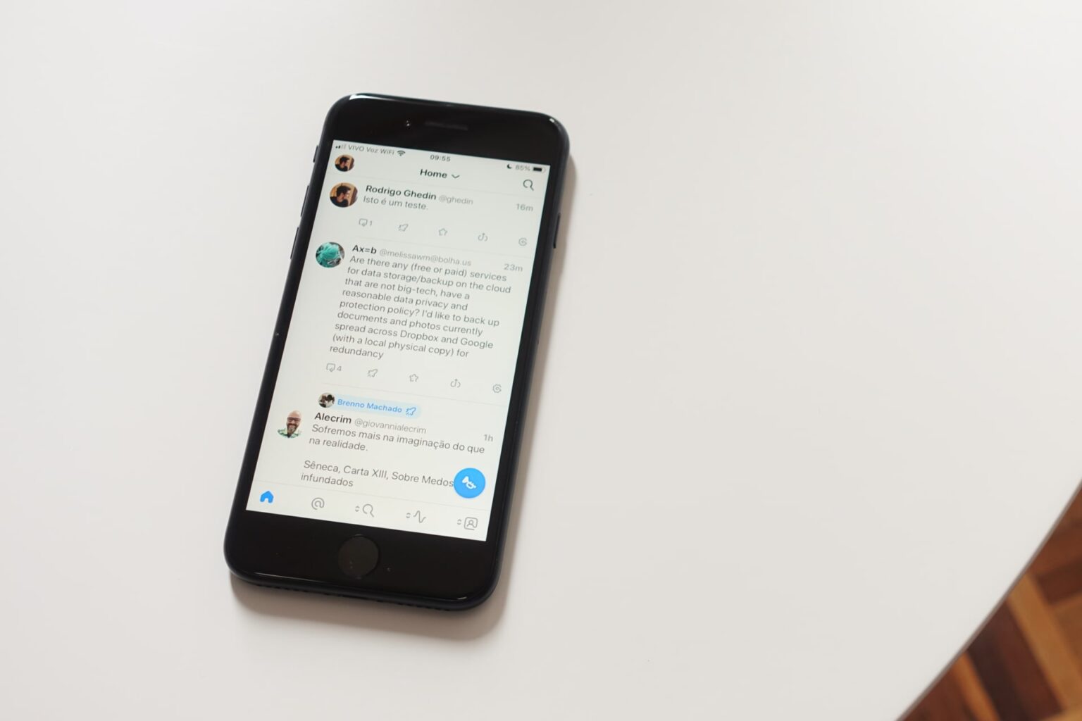 Foto de um iPhone SE sobre uma mesa branca, com a linha do tempo/tela inicial do Ivory aberta.