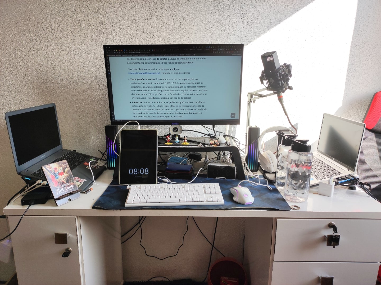 Foto frontal da mesa, com monitor ligado exibindo um texto.