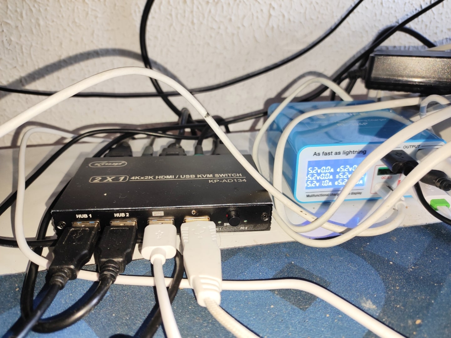 Detalhe do chaveador KVM com vários cabos conectados.