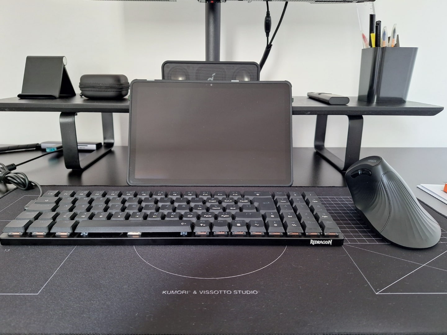 Foto frontal do tablet (com a tela desligada), teclado e mouse vertical.