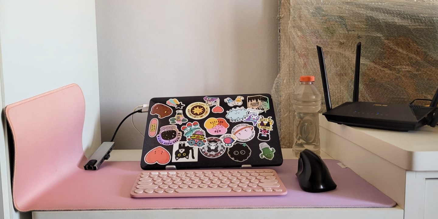 Notebook fechado com vários adesivos colados na tampa.