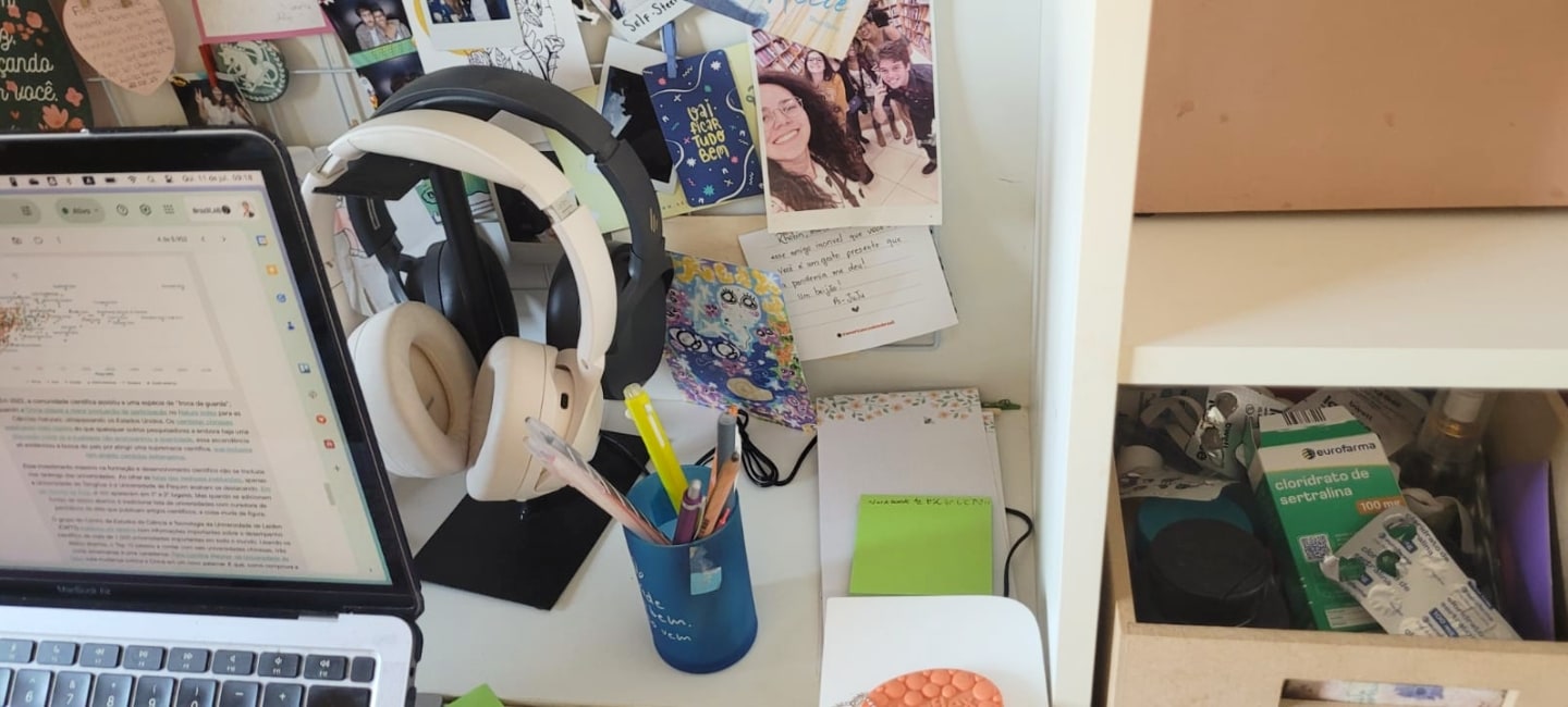 Fones de ouvido e enfeites de parede na mesa do Rhobin.