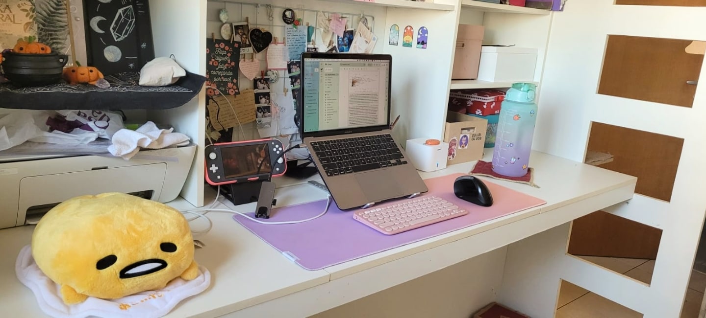 Vista lateral da mesa do Rhobin, com destaque para a pelúcia do Gudetama.