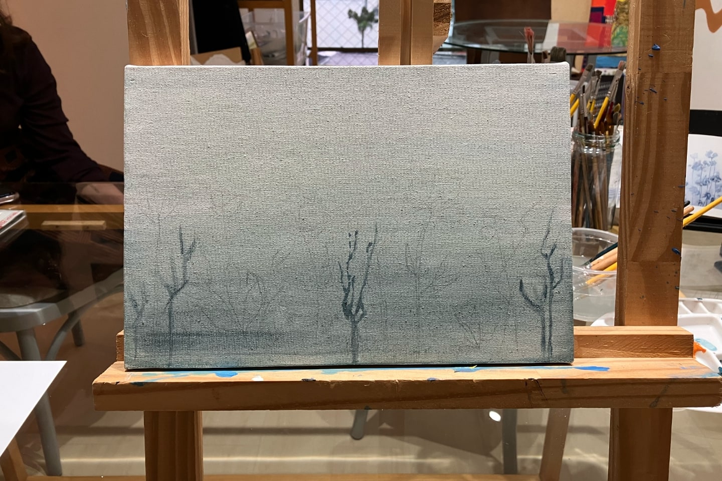 Parcial do primeiro quadro: gravetos na base e um fundo degradê, tudo em tons de azul acinzentado.