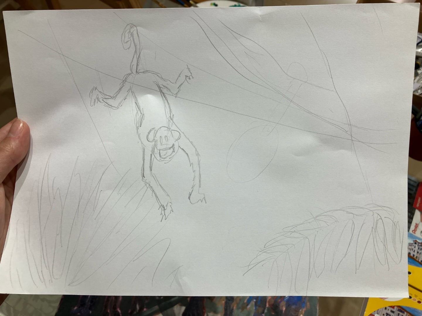 Esboço, com lápis em sulfite, de um macaco pendurado pelo rabo em um galho.