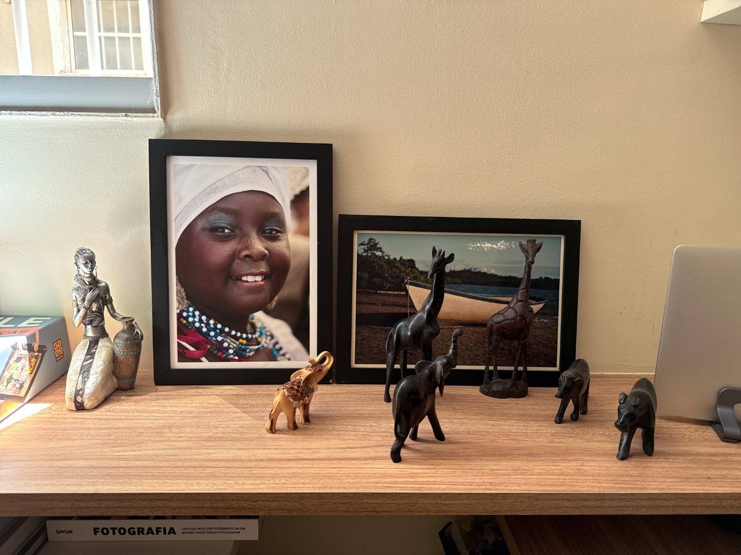 Fotos emolduradas e animais de madeira decorativos.