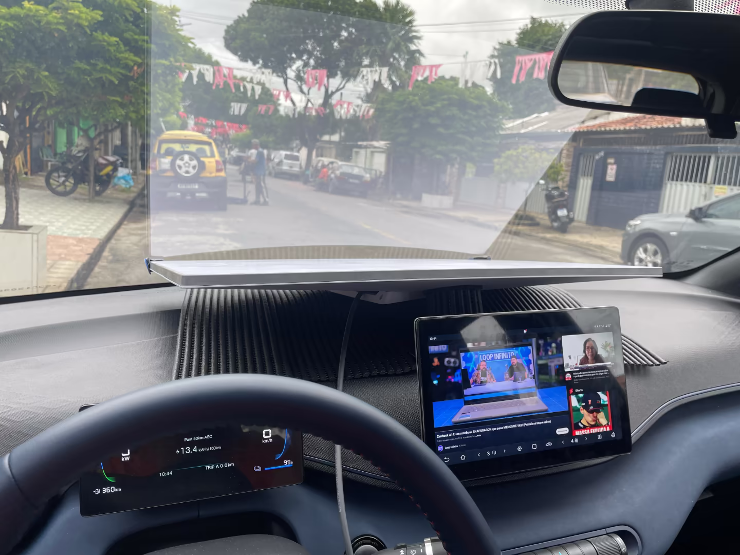 Visão parcial do painel de um carro, com uma antena encaixada rente ao parabrisa.