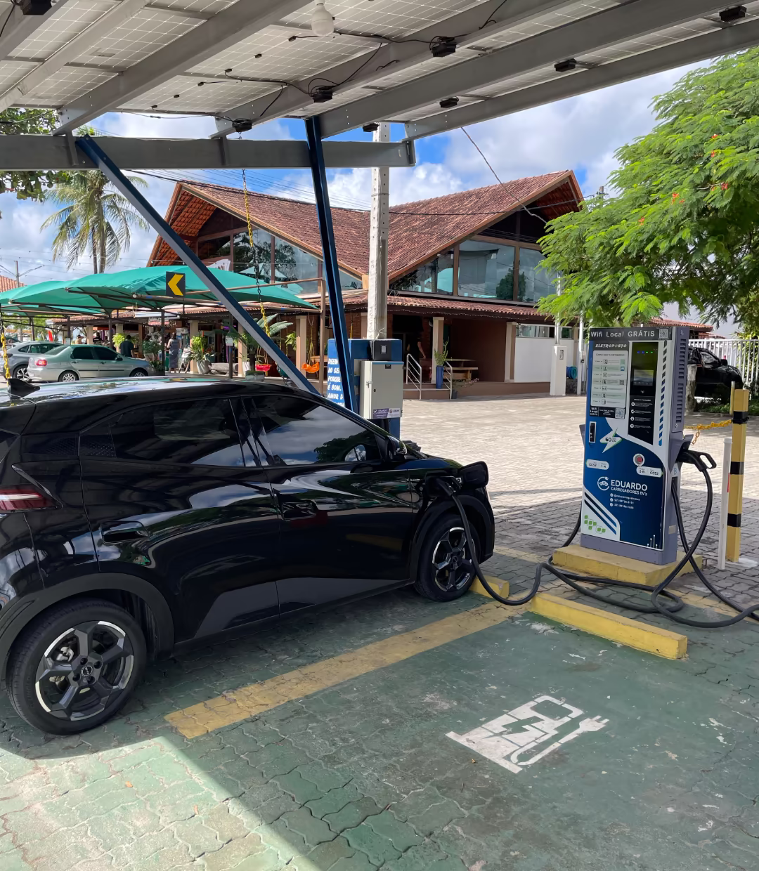 Carro preto em uma estação de recarga.