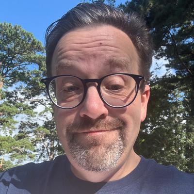 White man, with glasses and goatee, smiling.