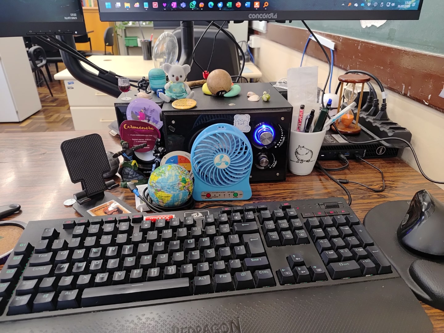 Detalhe do teclado e badulaques na mesa do Alessandro.