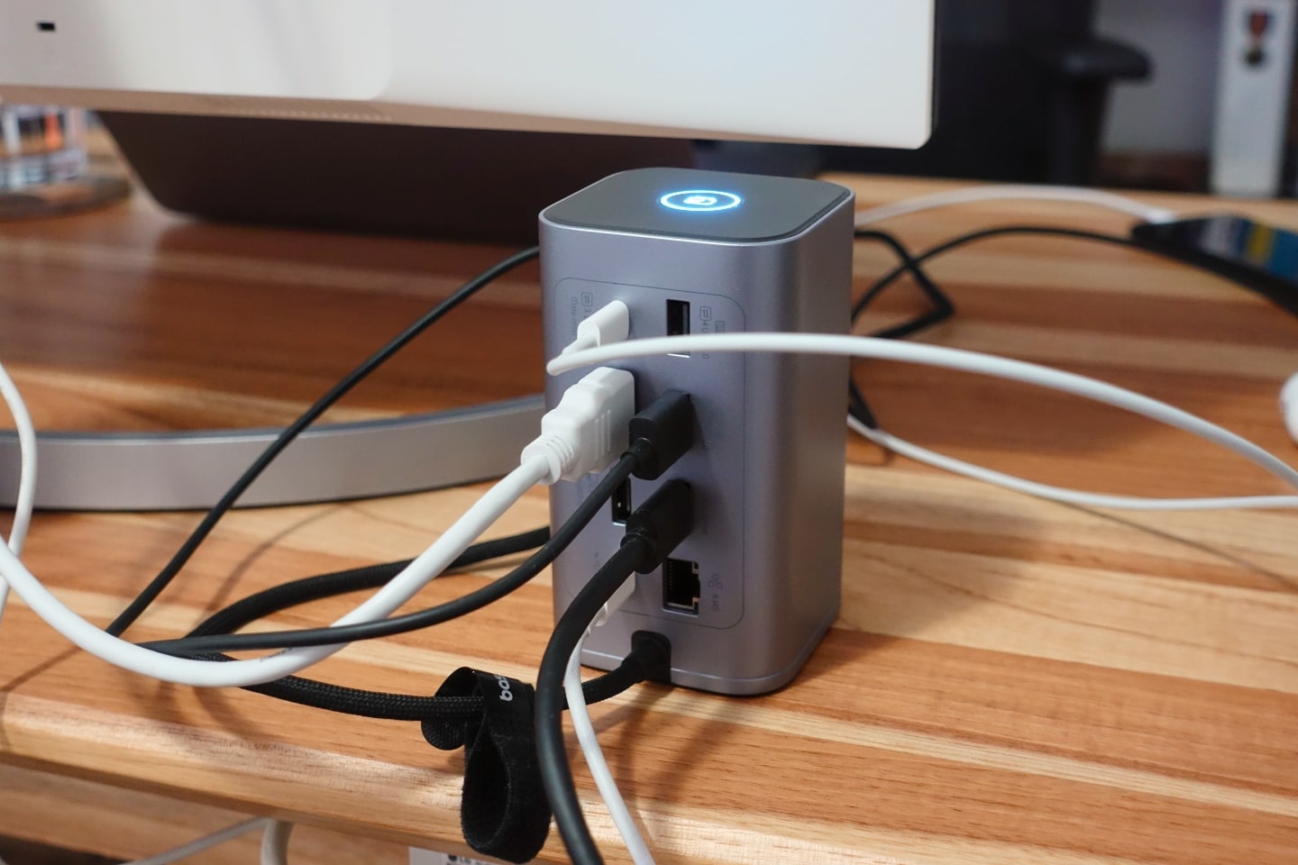 Foto por trás da dock/hub USB-C da Baseus, com vários cabos pretos e brancos conectados.