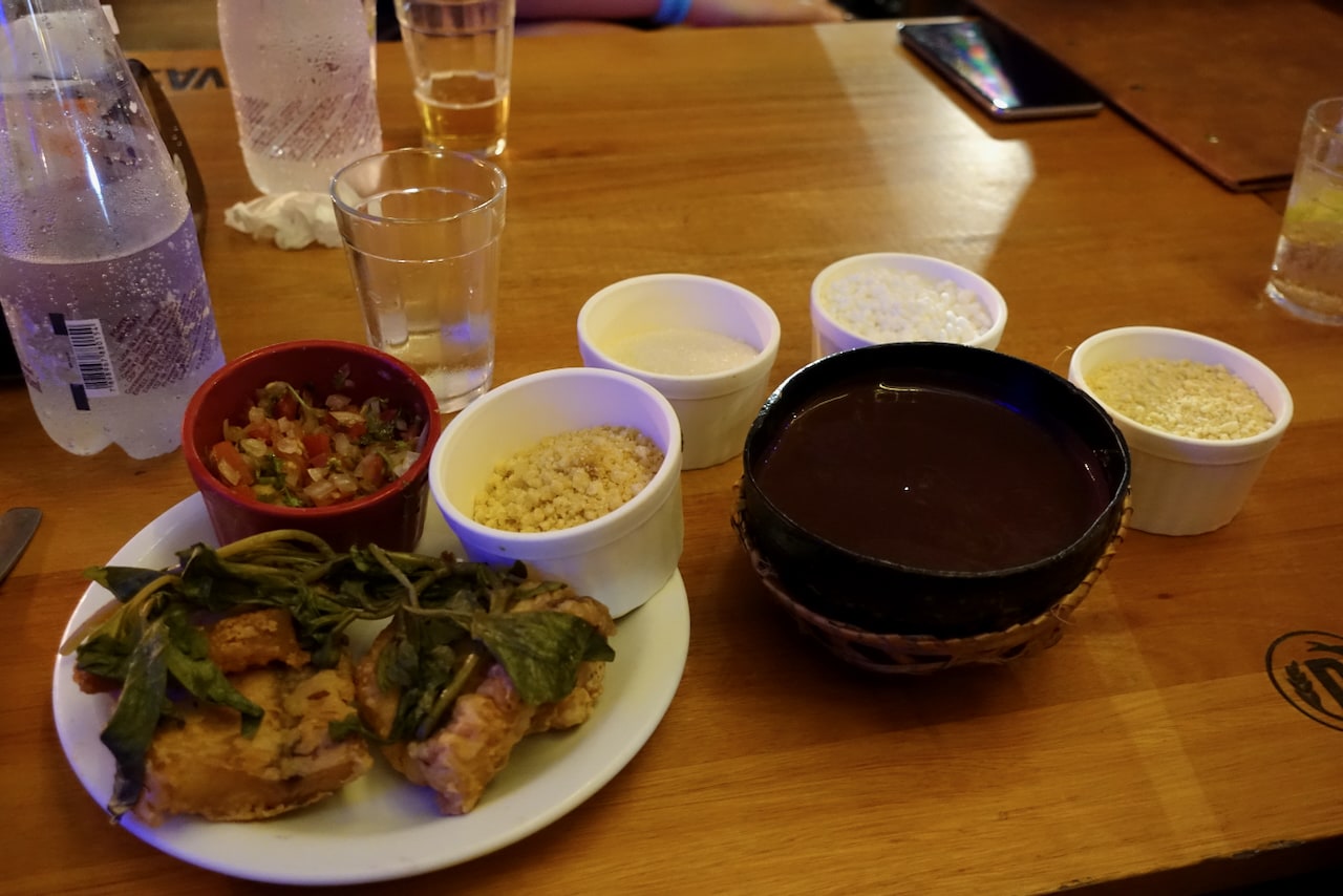 Plates on the table: filhote fillet with jambu leaves and a gourd of açaí.