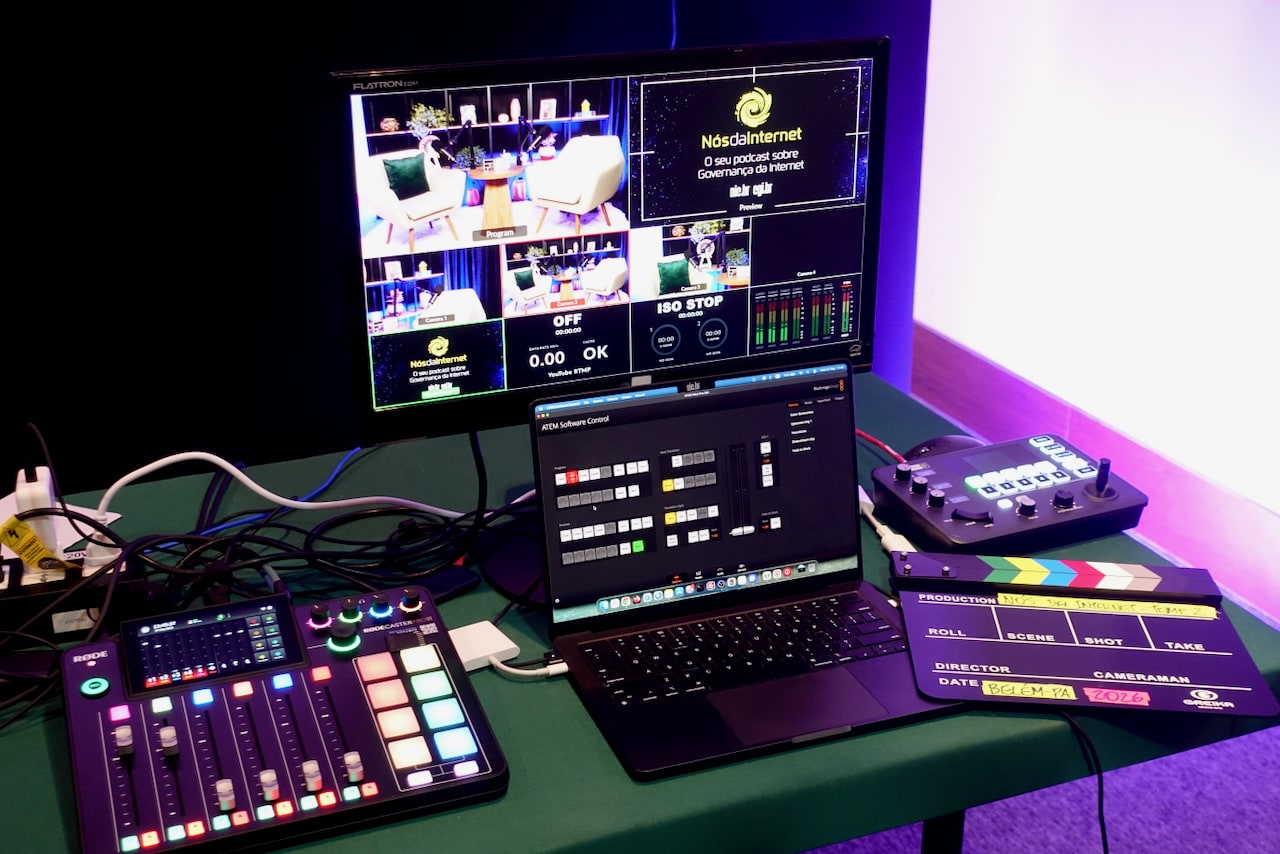 Table with notebook, monitor, clapperboard, and an audio mixer.