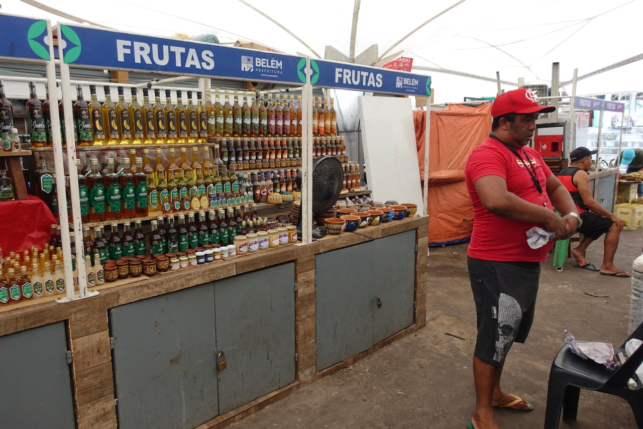 Cachaça stall with a man, the vendor, wrapping a bottle in paper.