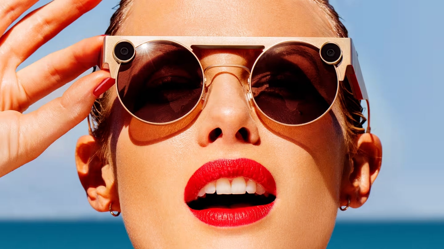 Foto de rosto, frontal, de uma mulher com batom vermelho e Spectacles 3 na cor rosa.