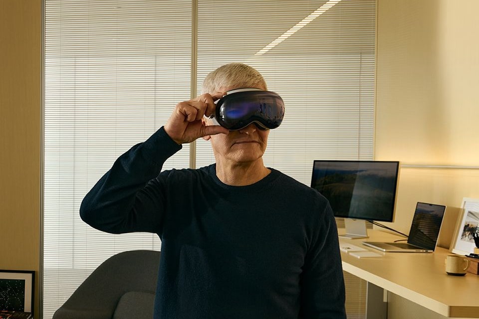 CEO da Apple, Tim Cook, vestindo o Vision Pro em um escritório à meia luz.
